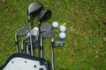 Closeup old golf bags on green. Set of golf clubs over green field background Royalty Free Stock Photo