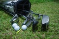 Closeup old golf bags on green. Set of golf clubs over green field background Royalty Free Stock Photo