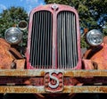 Closeup of an old grungy fire engine of a red truck under sunlight