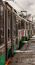 Closeup of an old grungy trolley driving past a station in winter in Brookline