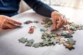 Closeup of the old hands playing with jigsaw puzzles