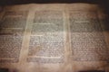 Closeup of an old Hebrew Bible on the table under the lights with a blurry background