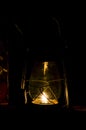 Closeup of an old hurricane lantern lighting and shinning with a flame of fire at night. Village oil lantern burning with kerosene Royalty Free Stock Photo