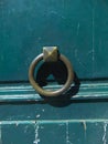 Closeup old iron door knocker on carved wooden door. Brass and steel craftsmanship Royalty Free Stock Photo