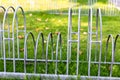 Closeup of old metallic bicycle parking racks in a field under the sunlight Royalty Free Stock Photo