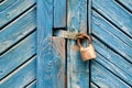 Closeup of old padlock on a weathered retro blue wooden door. Textured background. Royalty Free Stock Photo