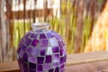 Closeup of an old purple mosaic vase on a wooden surface