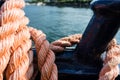 Closeup of an old red frayed boat rope, water background with landscape Royalty Free Stock Photo