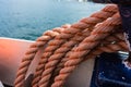 Closeup of an old red frayed boat rope, water background with landscape Royalty Free Stock Photo
