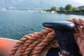 Closeup of an old red frayed boat rope, water background with landscape Royalty Free Stock Photo