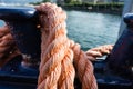 Closeup of an old red frayed boat rope, water background with landscape Royalty Free Stock Photo