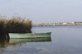 Closeup of old rustic wooden boat, calm river, dry reeds.Landscape view