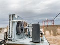 Closeup of an old and rusty ac compressor and fan on top of the roof and the fan of the unit is in the background Royalty Free Stock Photo