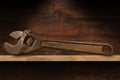 Old Rusty Adjustable Wrench on a Wooden Shelf Royalty Free Stock Photo