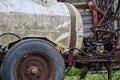 Closeup of an old rusty agricultural plastic tank for water or artificial fertilizers parked in woodlands