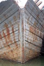 Closeup of an old rusty iron ship in a dirty sea under a bright sky Royalty Free Stock Photo