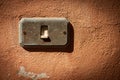 Old and rusty Light Switch on a red wall - Liguria Italy