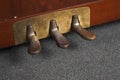 Closeup of old rusty piano pedals under the lights