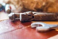 Closeup of an old, rusty plumbing wrench, blured wrench on the right. Focus on connecting screw, bokeh in the background, fiber an