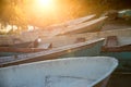 Closeup of old shabby wooden fishing colorful boats and boat bow during a sunset with sun rays Royalty Free Stock Photo