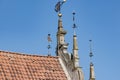 Closeup of and old style decorative ironwork on top of a building's roof against the blue sky