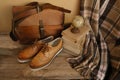 closeup old things, stack of vintage books, globe, shoes, leather military satchel on table, checkered grandmother\'s plaid,