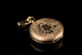 Old golden pocket watch on a black reflective surface Royalty Free Stock Photo