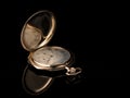 Old golden pocket watch on a black reflective surface Royalty Free Stock Photo