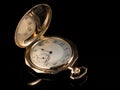 Old golden pocket watch on a black reflective surface Royalty Free Stock Photo