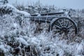 Closeup of an old wagon wheel covered with snow during winter time Royalty Free Stock Photo
