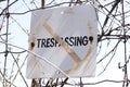 Closeup of old and weathered No trespassing sign posted to wire Royalty Free Stock Photo