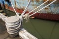 Old weathered rope white with a knot securing a fishing boat