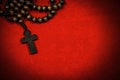 Old Wooden Crucifix with Rosary Beads on Red Velvet Background Royalty Free Stock Photo