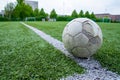 Closeup of an old worn-out soccer ball on a field with artificial grass Royalty Free Stock Photo