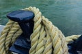 Closeup of an old yellow frayed boat rope, water background with landscape Royalty Free Stock Photo