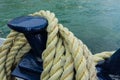 Closeup of an old yellow frayed boat rope, water background with landscape Royalty Free Stock Photo