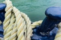 Closeup of an old yellow frayed boat rope, water background with landscape Royalty Free Stock Photo