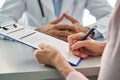 Closeup older patient filling medical heath data form in hospital clinic.