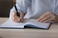 Closeup older woman holds pen writes in personal paper organizer