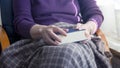 Closeup of older woman sitting by window and reading a book Royalty Free Stock Photo