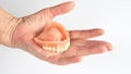 Closeup of older womans hand holding dentures