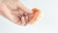 Closeup of older womans hand holding dentures