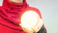 Older womans hand holding a shiny glass sphere