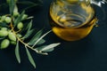 Closeup Olives, oil and green branch on black background Royalty Free Stock Photo
