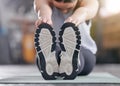 Closeup of one active caucasian woman touching her feet and stretching legs for warmup to prevent injury while Royalty Free Stock Photo