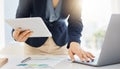 Closeup of one businesswoman using a digital tablet device and laptop while planning notes at a desk in an office. Hands Royalty Free Stock Photo