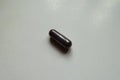 Closeup of one dark purple capsule of bilberry extract dietary supplement