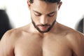 Closeup of one fit topless mixed race man with strong defined pectoral muscles from regular exercise in a gym