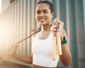 Closeup of one fit young hispanic woman holding a jumping rope for skipping while exercising in an urban setting Royalty Free Stock Photo