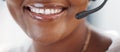 Closeup of one happy african american call centre telemarketing agent with big smile talking on headset while working in Royalty Free Stock Photo